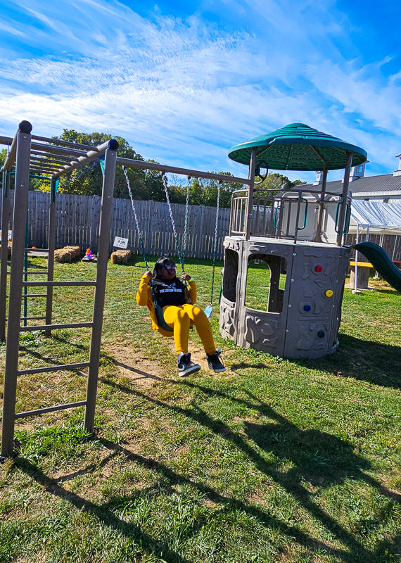 A student swinging on the playground on a bright afternoon