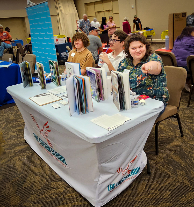 Edison students at their table of handmade yearbooks at a community expo