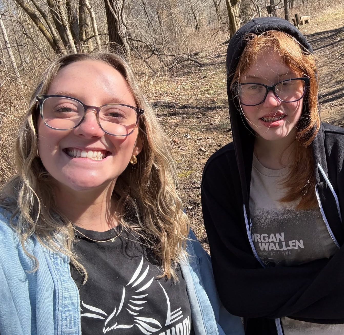 Austin outdoors on an Edison school trip, smiling beside a classmate on a wooded trail